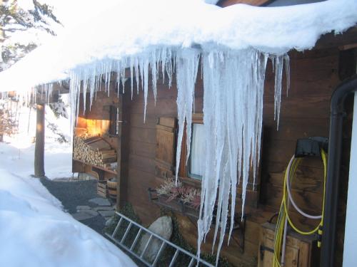 a building with icicles hanging from it in the snow at Haus Elisengrund am Geigenbuehel - chalet privé in Seefeld in Tirol