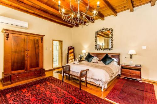 a bedroom with a bed and a chandelier at Lemoenkloof Boutique Hotel in Paarl