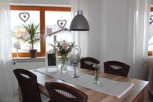 una mesa de comedor con flores en jarrones. en Ferienwohnung Stadtidyll, en Michelstadt