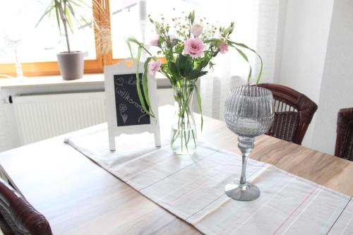 una mesa con un jarrón de flores sobre una mesa en Ferienwohnung Stadtidyll, en Michelstadt