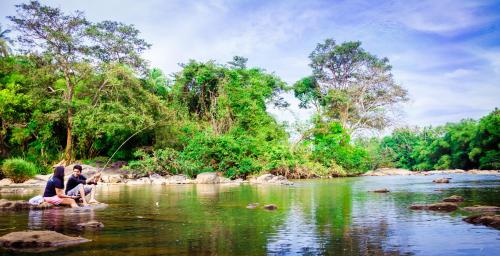 two people sitting in the water fishing in a river at Roshara Nalla in Giriulla