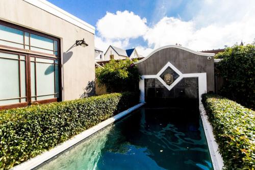 a house with a swimming pool next to a building at Lemoenkloof Boutique Hotel in Paarl