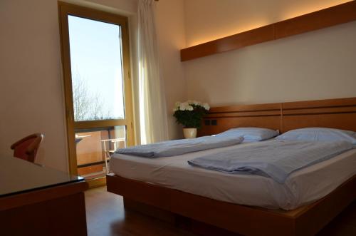 a bedroom with a large bed with a window at Parc Hotel Casa Mia in Lazise