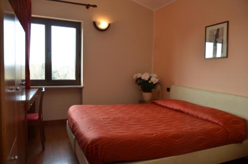 a bedroom with a bed and a window and a vase of flowers at Parc Hotel Casa Mia in Lazise