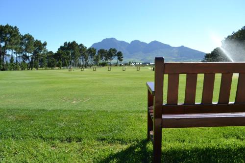 a park bench sitting in a field of grass at Pearl Valley-Golf Safari SA in Paarl