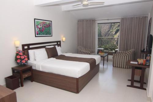 a bedroom with a large bed and a window at Abad Copper Castle Resort in Munnar