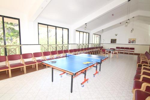 a ping pong table in a room with chairs at Abad Copper Castle Resort in Munnar