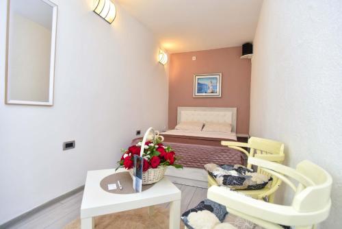 a small room with a bed and a table and chairs at Klaris Guest house in Budva