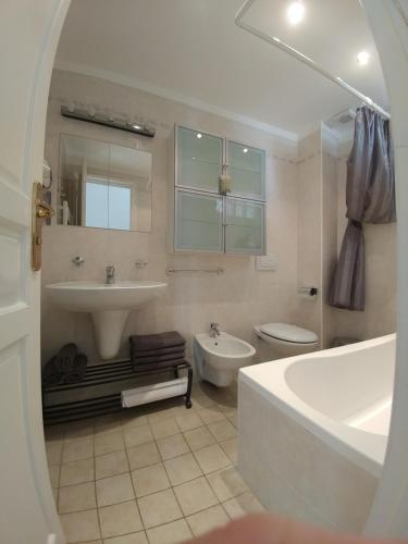 a bathroom with a tub and a sink and a toilet at Sea Apartment in Sanremo