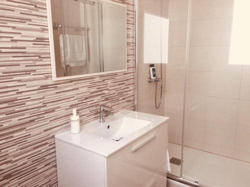 La salle de bains est pourvue d'un lavabo, d'un miroir et d'une douche. dans l'établissement Piso céntrico Plaza Toros, à Valence