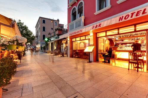 a city street with shops and people walking down the street at New Reiter Hotel in Venice-Lido