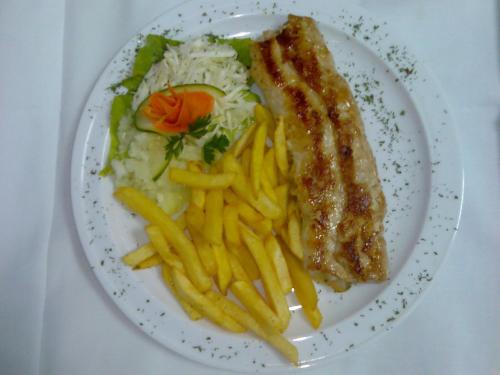 a plate of food with french fries and meat at Hotel Vila Sunce in Stara Pazova