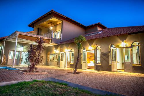 a large house with a driveway in front of it at Blue Rain Guest House in Bloemfontein