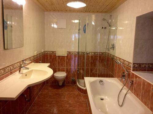 a bathroom with a sink and a tub and a toilet at Ferienwohnung Am Grünbach in Kurort Rathen