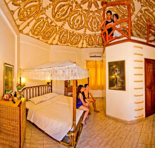 um grupo de pessoas sentadas numa cama num quarto em Dolce Vita Hotel em Puerto Princesa