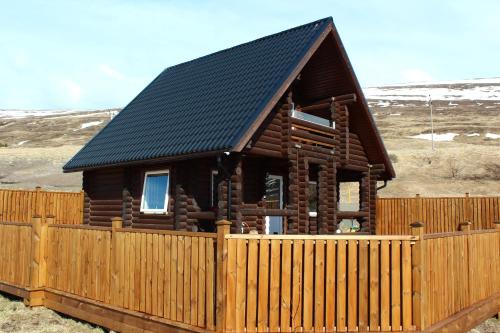 a log cabin behind a wooden fence at Akureyri Log Cottage in Akureyri