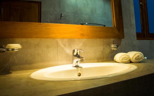 um lavatório na casa de banho com um espelho e toalhas em Roshara Nalla em Giriulla