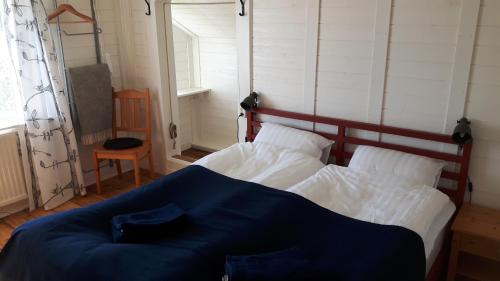a bedroom with a bed with a blue blanket on it at The Sheep Inn B&B in Arvika