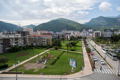 a city with a park and buildings and mountains at Apartman Anna Tre Canne Budva in Budva