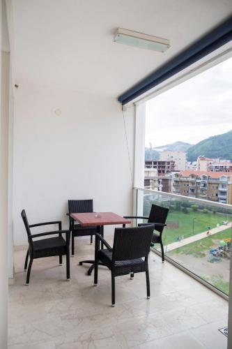 a patio with a table and chairs and a large window at Apartman Anna Tre Canne Budva in Budva