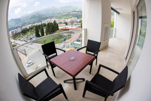 a table and chairs in a balcony with a view at Apartman Anna Tre Canne Budva in Budva