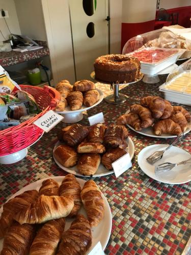 a table topped with plates of bread and pastries at PFA Hotel La Darsena - Follonica in Puntone di Scarlino