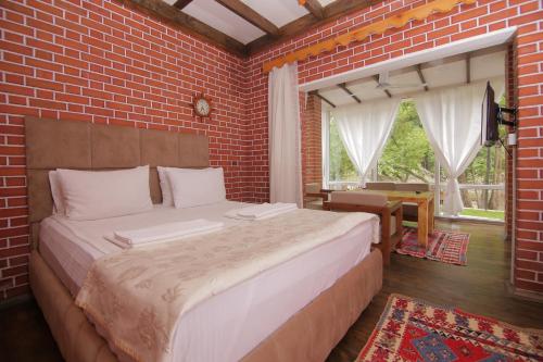 a bedroom with a large bed in a brick wall at Basharu resort in Lankaran