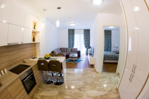 a kitchen and a living room with a table at Apartman Anna Tre Canne Budva in Budva
