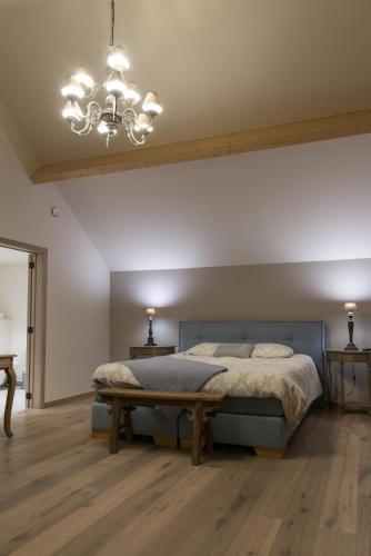 a bedroom with a bed and a chandelier at B&B De Windheer in Sint-Martens-Lennik
