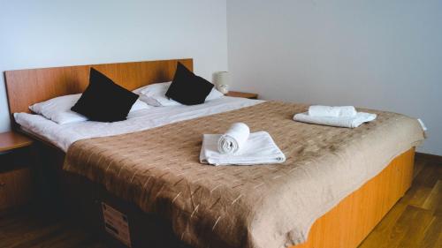 a bedroom with a bed with two towels on it at Pensiunea Codruta in Carpinis