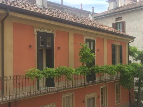 Palazzo Carasi Apartments في كريمونا: مبنى برتقالي مع نباتات على شرفة