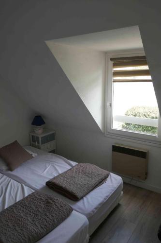 ラ・トリニテ・シュル・メールにあるTy Lochのベッドルーム1室(ベッド2台、窓付)