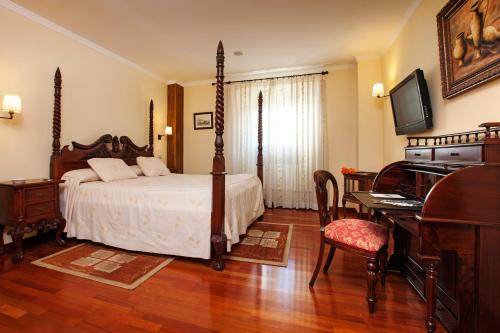 a bedroom with a bed and a desk and a piano at Finca Eslava in Antequera