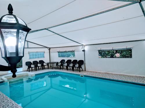 a swimming pool with chairs and a light fixture at beit nofesh waiss in Beit Hillel