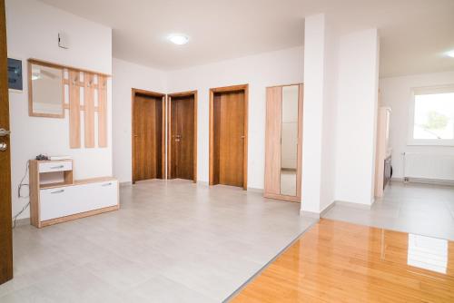 um quarto vazio com portas de madeira e pisos de madeira em Tina Rooms em Velika Gorica