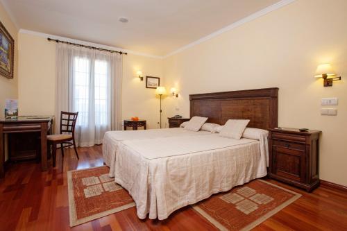 a bedroom with a bed and a desk and a table at Finca Eslava in Antequera