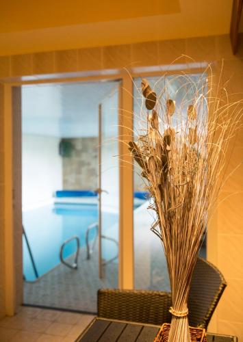 a vase filled with dried grass sitting on a table at Landhaus Fischer in Sankt Andreasberg