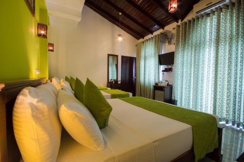 Кровать или кровати в номере Ceyloni Lake Residency