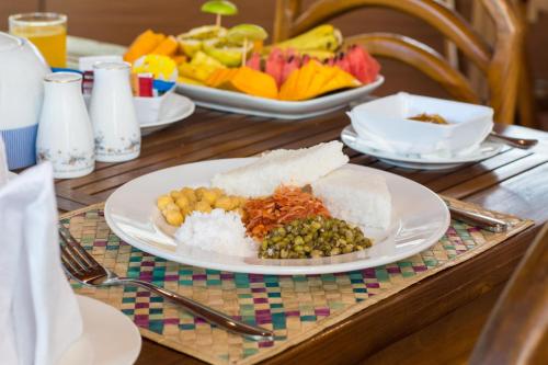 uma mesa com um prato de comida com arroz e frutas em Ceyloni Lake Residency em Kandy