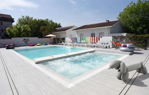 a swimming pool with chairs and a house at Love Boat Hotel - The Original in Riccione