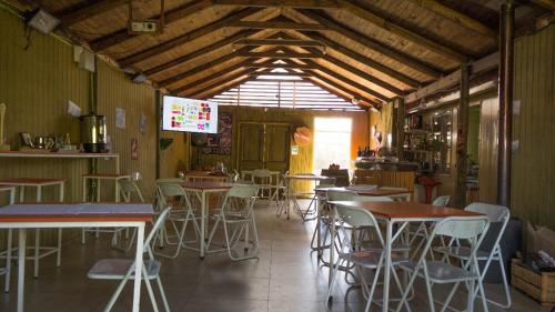un restaurante con mesas y sillas en una habitación en Cabañas Turisticas de la Yayita, en Río Claro