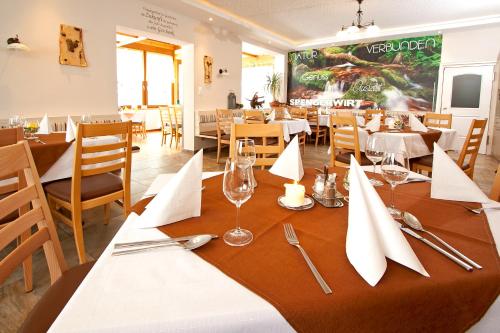 a dining room with a table with glasses and napkins at Gasthof Spengerwirt in Hirschegg Rein