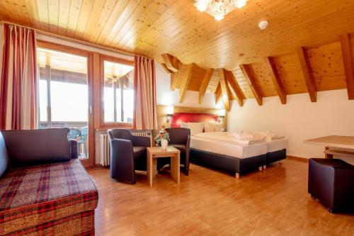 a bedroom with a bed and a couch and a table at Wellnesshotel Sonnenhof & Sonnhalde in Ühlingen-Birkendorf