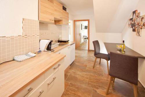 a kitchen with a counter and a table and chairs at Gasthof Spengerwirt in Hirschegg Rein