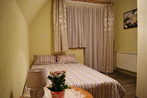 ニエジツァ・ザメクにあるPokoje u Kordeckichのベッドルーム1室(ベッド1台、花のテーブル付)