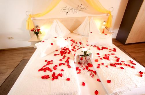 a bedroom with a bed with red roses on it at Gasthof Spengerwirt in Hirschegg Rein
