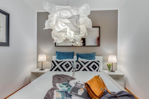 a bedroom with a bed and a chandelier at Main Street apartments in Rijeka