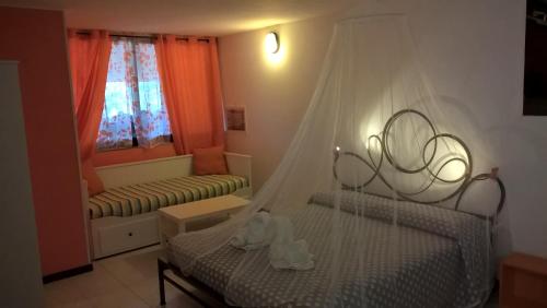 a bedroom with a bed with a mosquito net at Casetta delle Fate , sport e natura in Noli
