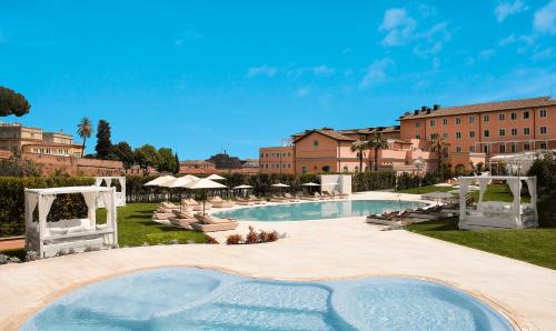 a large pool with chairs and a building in the background at Villa Agrippina Gran Meliá – The Leading Hotels of the World in Rome