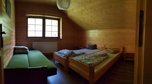 sypialnia z 2 łóżkami w drewnianym domku w obiekcie Pensjonat Danielka w mieście Ujsoły